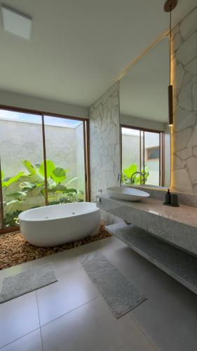 two sinks in a bathroom with two mirrors at Casa Vista Serrana in São Pedro