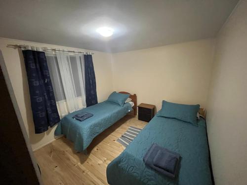 a small bedroom with two beds and a window at Cabañas Sol y Mar in Puerto Montt