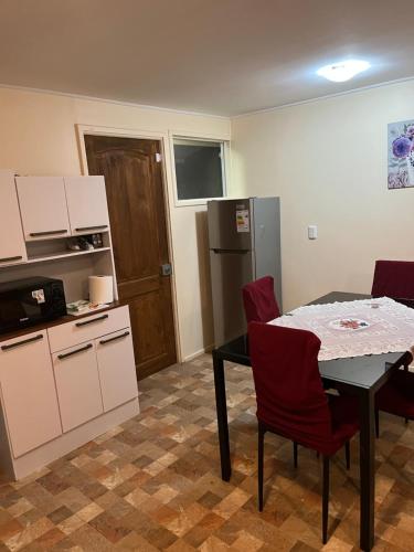 a kitchen with a table and red chairs in a room at Cabañas Sol y Mar in Puerto Montt