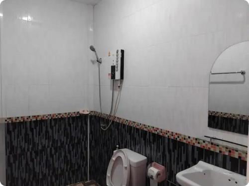 a bathroom with a toilet and a sink and a mirror at K and K Resort room 1 in Prakhon Chai