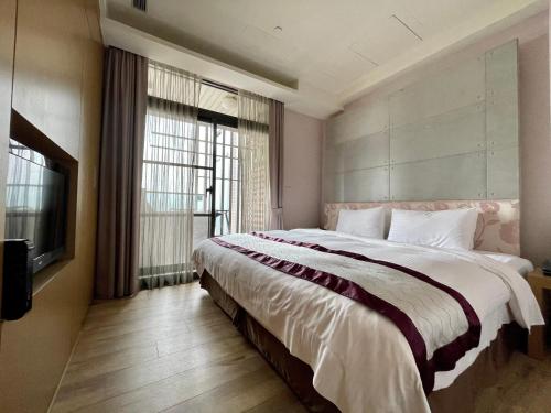 Master Hotel في تايبيه: غرفة نوم بها سرير كبير ونافذة كبيرة