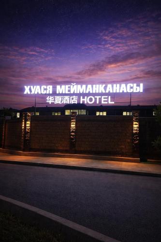 a building with a sign on the side of it at Huaxia Hotel Bishkek in Bishkek