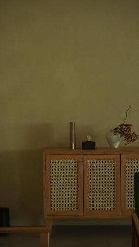 a wooden cabinet with a vase on top of it at 雲居月-kumoizuki- in Ginowan