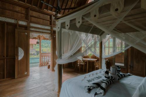 a bedroom with a canopy bed and a table at Green vanilla mincung 2 in Silebeng