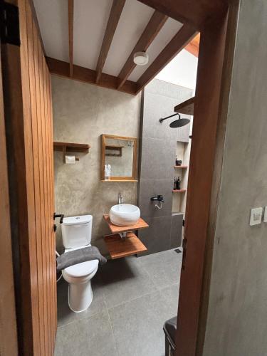 a bathroom with a toilet and a sink at Pam's Cabin Batukaras in Batukaras