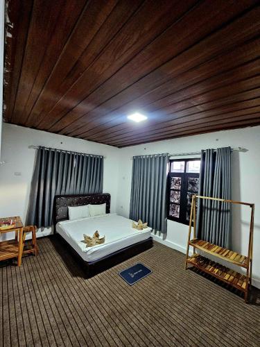 a bedroom with a bed and a wooden ceiling at Apatuxay Vientiane Hostel in Vientiane