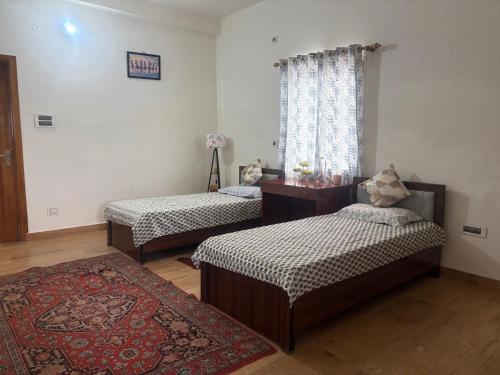 a room with two beds and a window at Deepalaya in Guwahati