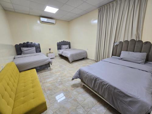 a room with two beds and a couch in it at NMY Farm1 in Ras al Khaimah