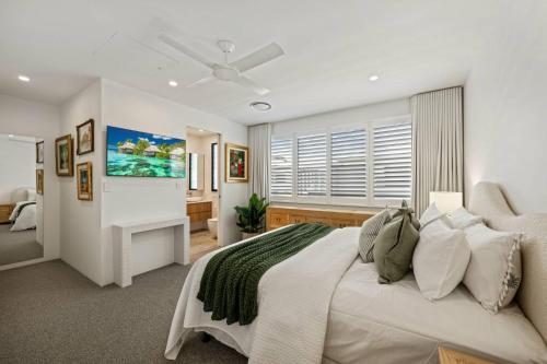a bedroom with a large white bed and a window at Noosa Village River Resort in Noosaville