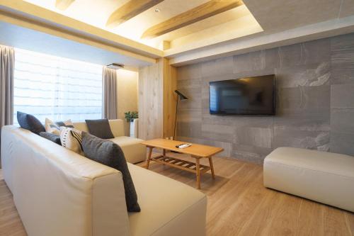 a living room with a couch and a tv at PREMIER suite Shinjuku West 3F 4F in Tokyo