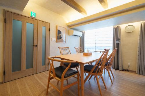 a dining room with a wooden table and chairs at PREMIER suite Shinjuku West 3F 4F in Tokyo