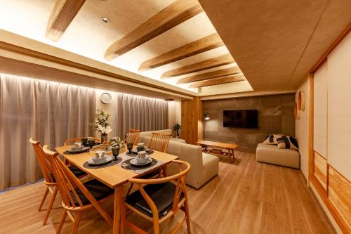 a dining room with a table and a couch at PREMIER suite Shinjuku West 3F 4F in Tokyo