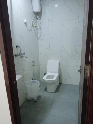 a white bathroom with a toilet and a sink at HOTEL SHIVAAY near by urban Square mall and nexus celebration mall in Bedla