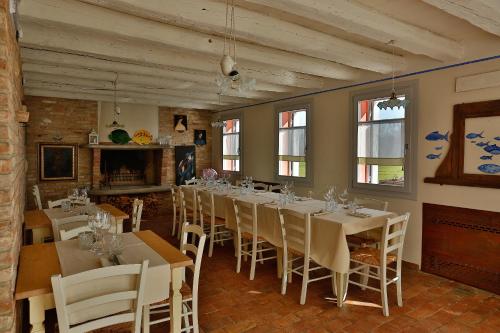 a dining room with white tables and white chairs at Locanda Acciuga MM in Piazzola sul Brenta