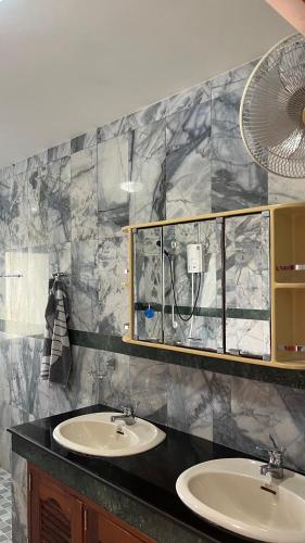 a bathroom with two sinks and a mirror at Liina House in Ko Yao Noi
