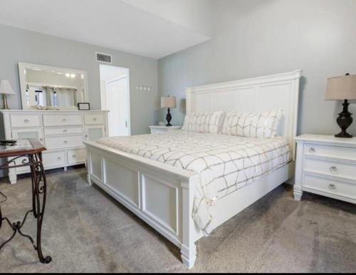 a bedroom with a large white bed and a mirror at Sugar Beach 330 Family Friendly Vacation Sleeps 8 in Gulf Shores