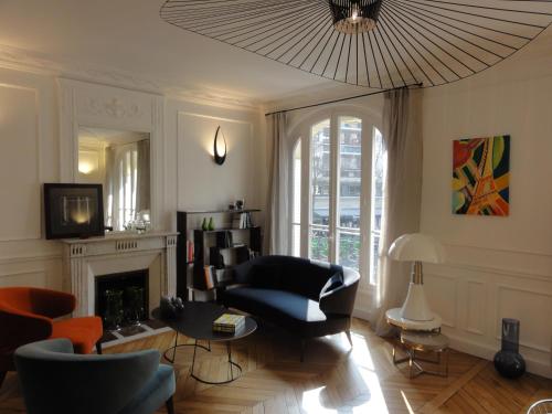 a living room with a couch and chairs and a chandelier at Relais12bis Bed & Breakfast By Eiffel Tower in Paris