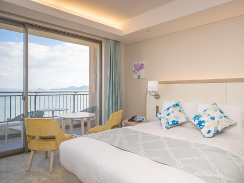 a hotel room with a bed and a balcony at Karatsu Seaside Hotel in Karatsu