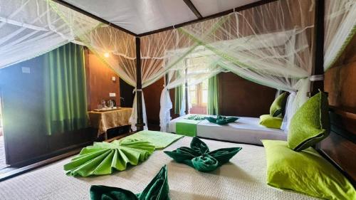a bedroom with a bed with green pillows on it at Sigiri Aliya Tree house in Sigiriya