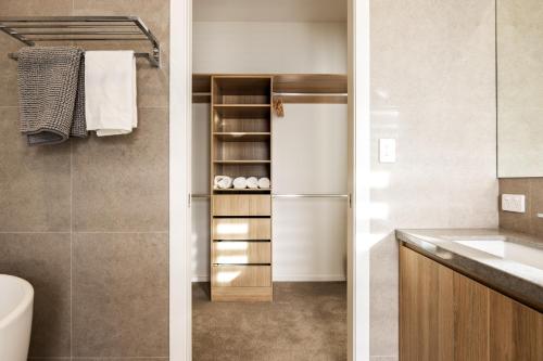 two views of a bathroom with a refrigerator and a sink at Shining House Villa B in Tanunda