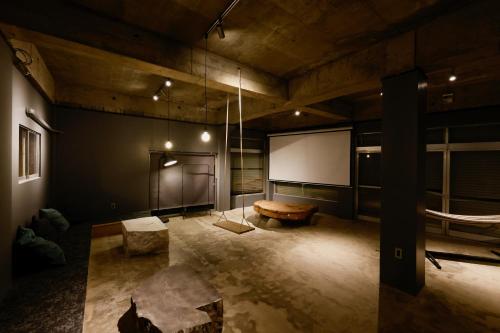 a large room with a couch and a projector screen at RITO SAKAPORT サウナ付き一棟貸しVilla in Tsushima