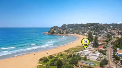 a kite flying over a beach next to the ocean at Pacific Court 'absolute Beachfront=' in Avoca Beach