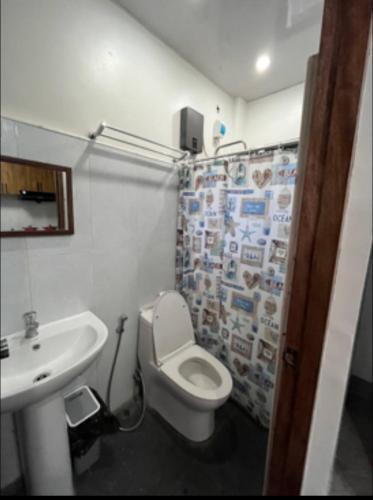 a bathroom with a white toilet and a sink at Two-Storey Townhouse in Laguindingan