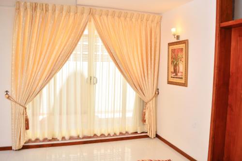 a large window with curtains in a room at Unique Towers Luxury Boutique Suites in Colombo