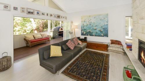 a living room with a couch and a fireplace at Mackaren's Lodge - Chic in Macmasters Beach