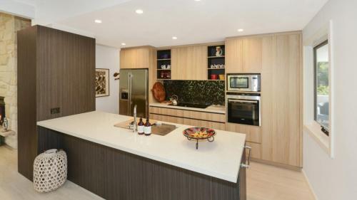 a kitchen with a white counter top and a stove at Mackaren's Lodge - Chic in Macmasters Beach