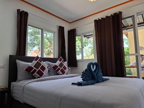a bedroom with a bed with a blue stuffed animal on it at NO name bangalow in Ko Lanta Yai