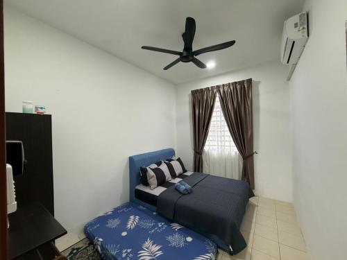 a bedroom with a bed and a ceiling fan at Hasna Homestay Cherating Muslimonly in Kuantan