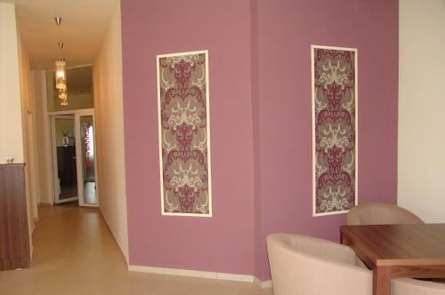 a dining room with purple walls and a table at Hotel Liliacul in Cluj-Napoca