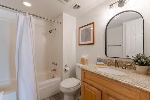 a bathroom with a toilet and a sink and a mirror at Central Phoenix Townhome in Phoenix
