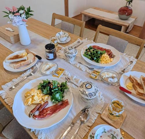 a wooden table with plates of food on it at MyBound Homestay Zushi in Zushi