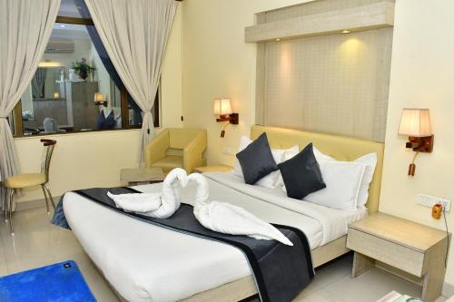 a hotel room with two swans on a bed at The Rass in Kānpur