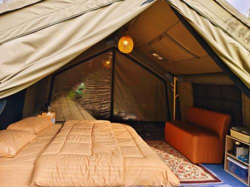 a bed in a tent with a bird in the window at Doi Inthanon Waterfall Garden in Ban Sop Mae Klang