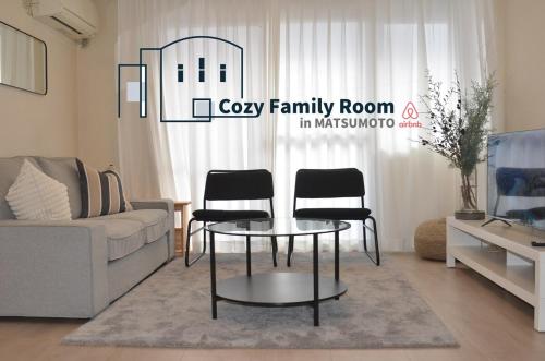 a living room with a couch and a table and chairs at Cozy Family Room in Matsumoto 201 in Matsumoto