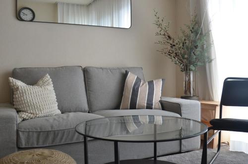 a living room with a couch and a glass table at Cozy Family Room in Matsumoto 201 in Matsumoto