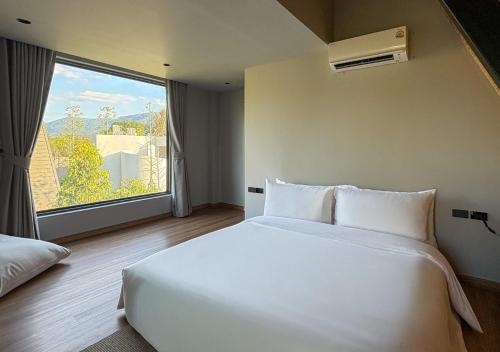 a white bed in a room with a large window at Khunkhao Paradise Khao Yai in Ban Rai Khlong Sai