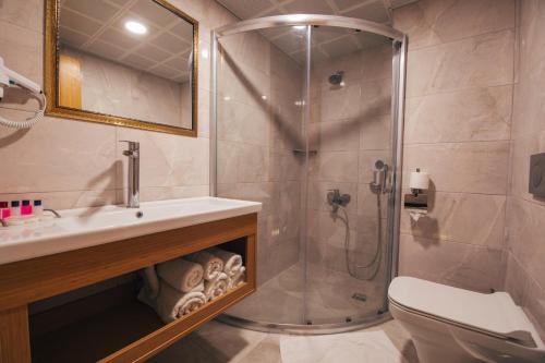 a bathroom with a shower and a sink and a toilet at Royal Mersin Otel in Mersin