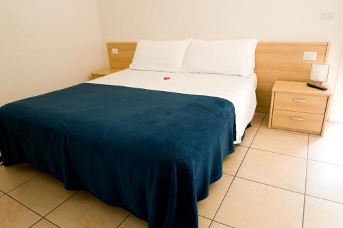 a bedroom with a bed with a blue blanket on it at B&B Daniel in Silea