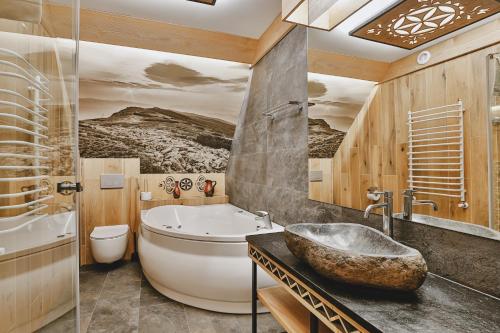 ein Badezimmer mit Badewanne, Waschbecken und Badewanne in der Unterkunft Hotel&SPA Jawor in Zawoja