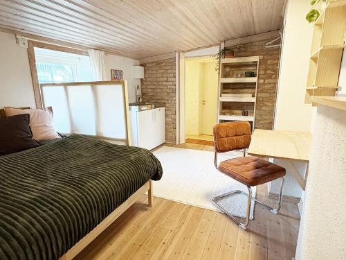a bedroom with a bed and a desk and a chair at Rabygatan cottage in Old Limhamn in Malmö