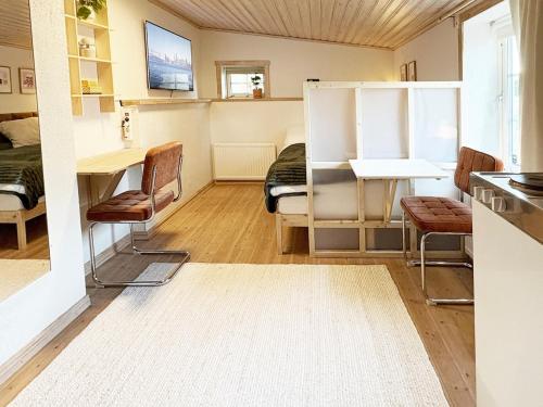 a room with a bed and a table and chairs at Rabygatan cottage in Old Limhamn in Malmö