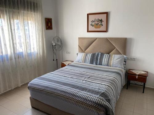 a bedroom with a bed and a window with a fan at La esquina in Martil