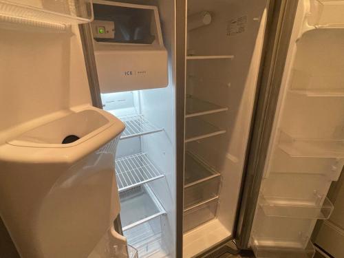 an empty refrigerator with its door open and its shelves at Inner Haven Family Homes in Indianapolis
