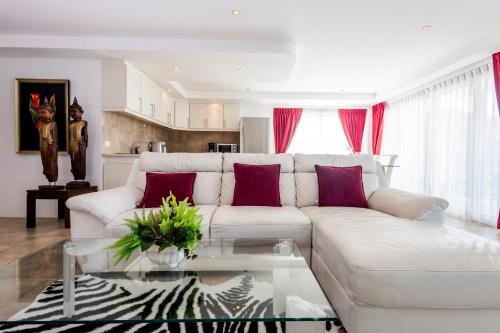 a living room with a white couch and a glass table at ELEGANT Kata sea View Apartmens in Kata Beach