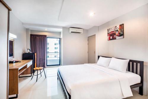 ein Hotelzimmer mit Bett und Schreibtisch in der Unterkunft Aliz Hotel in Nonthaburi