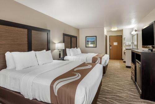 a hotel room with two beds and a flat screen tv at Quality Inn & Suites South Fork - Wolf Creek in South Fork